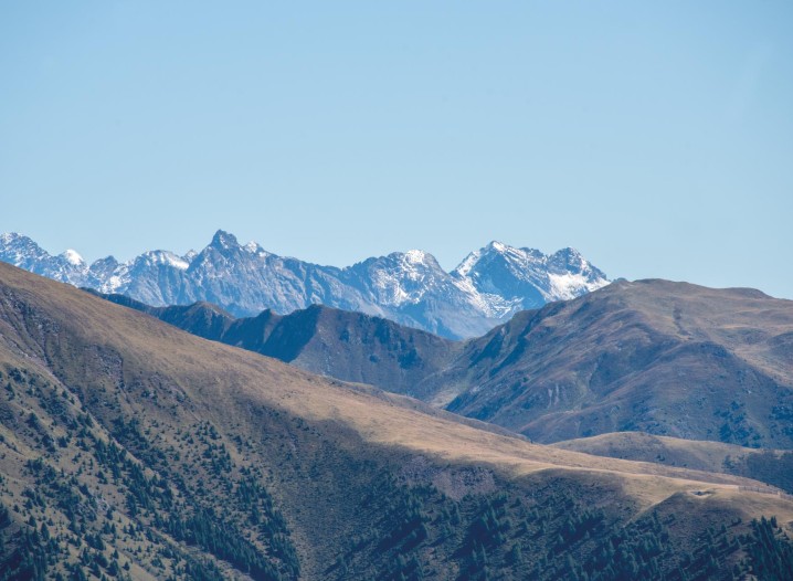Mountain panorama with blue sky. There is snow on the mountains in the background.